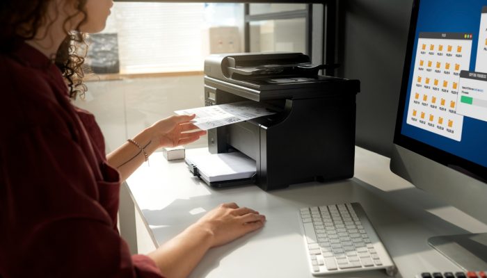 Entrepreneuse qui imprime des documents avec une imprimante HP hacker.